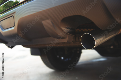 closeup car exhaust pipe with soft-focus and over light in the background
