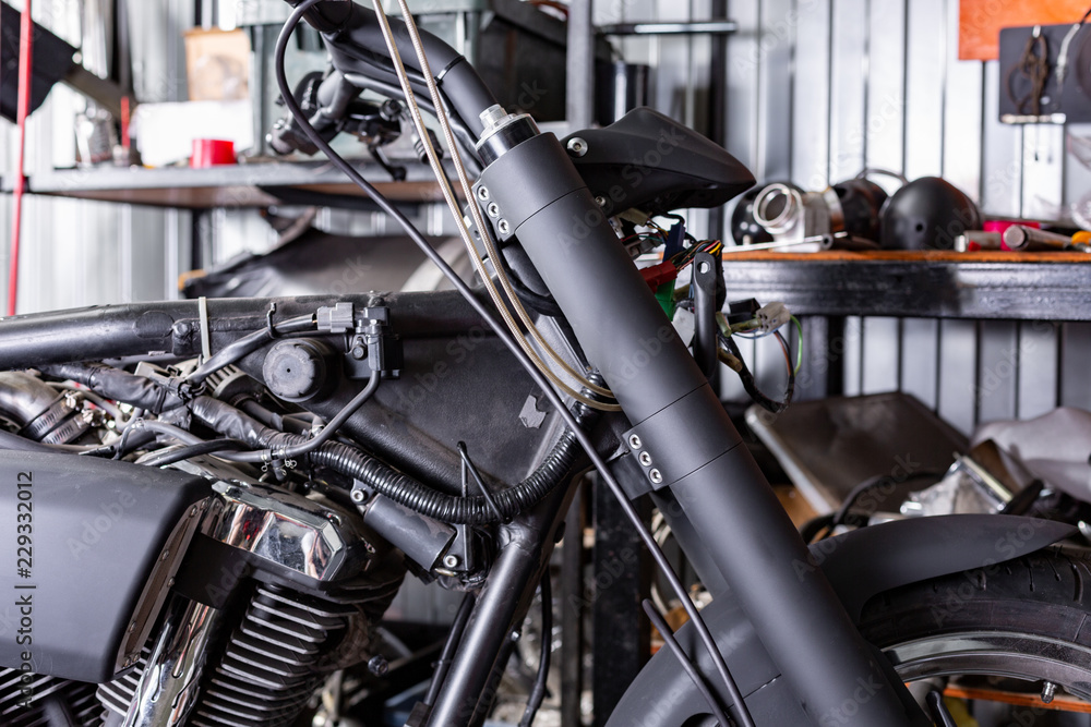 Cropped close up shot of beautiful and custom made motorcycle in the workshop Cropped close up shot of beautiful and custom made motorcycle in the workshop