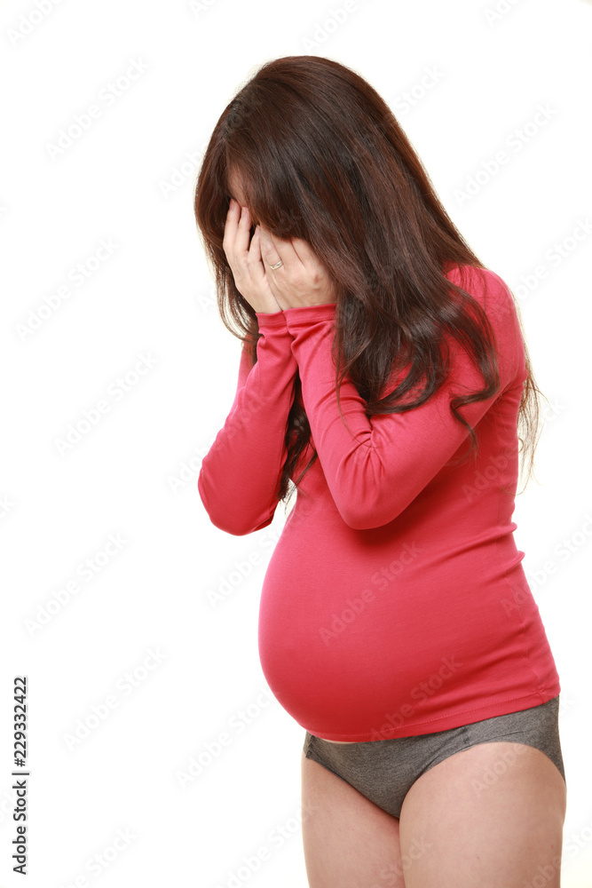 マタニティブルーに襲われる赤いシャツを着た臨月の妊婦 Stock Photo Adobe Stock