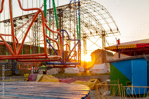 Close-up of empty carousel roundabout chain ride at sunset photo