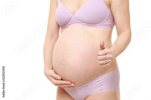 妊娠の経過が順調なことに満足する薄紫色の下着を着た臨月の妊婦