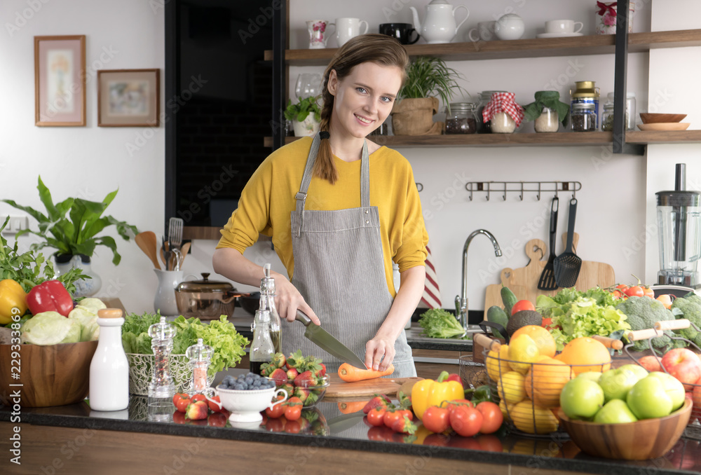 Healthy young woman in a kitchen preparing fruits and vegetables for healthy meal and salad Healthy young woman in a kitchen preparing fruits and vegetables for healthy meal and salad