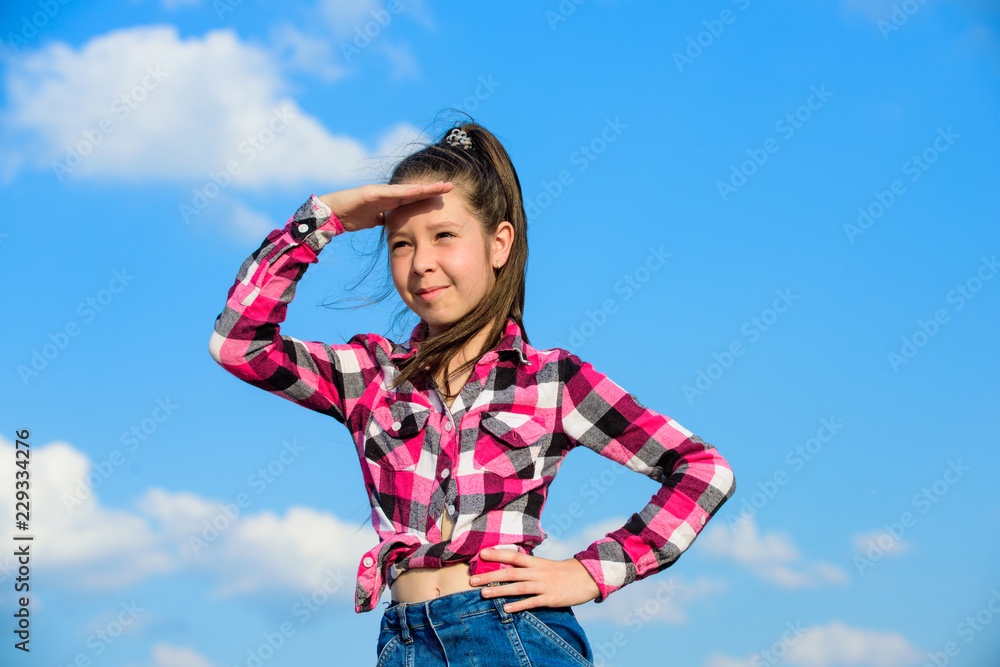 Kid girl checkered fashionable shirt posing sunny day blue sky background. Child cute girl long hair ponytail hair. Fashion model girl. Stylish fashionable kid. Kids fashion concept Kid girl checkered fashionable shirt posing sunny day blue sky background. Child cute girl long hair ponytail hair. Fashion model girl. Stylish fashionable kid. Kids fashion concept