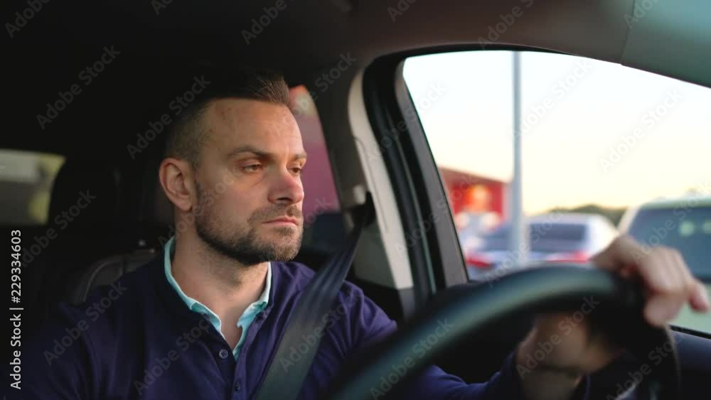 Man driving a car, looking for a place to park Man driving a car, looking for a place to park