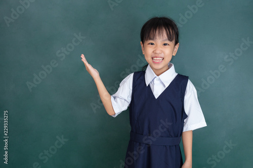 Asian Chinese little girl standing in front of green blackboard