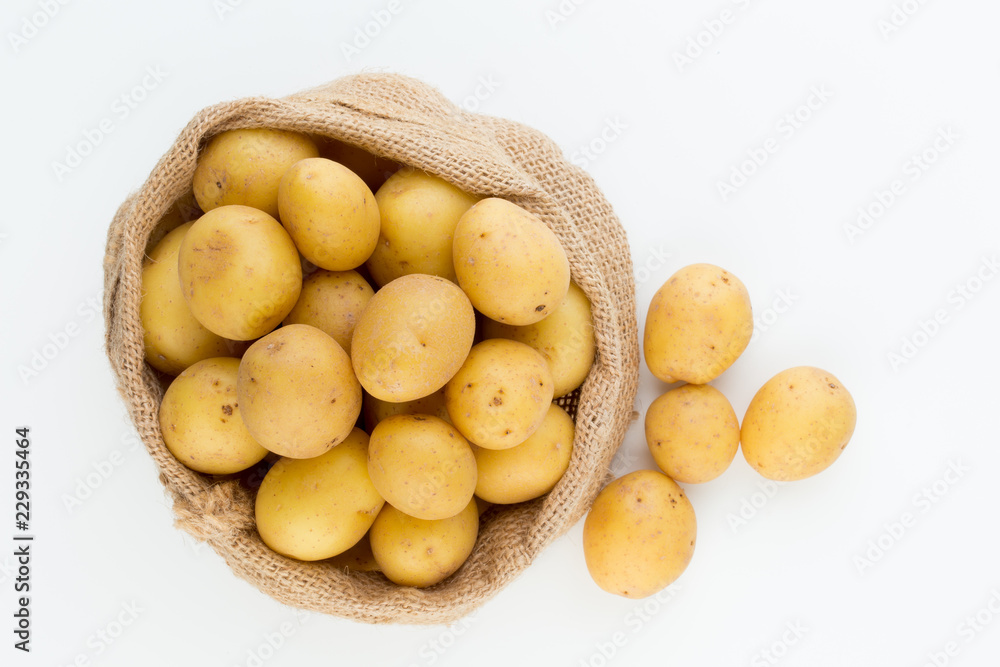 Sack of fresh raw potatoes on wooden background, top view Sack of fresh raw potatoes on wooden background, top view