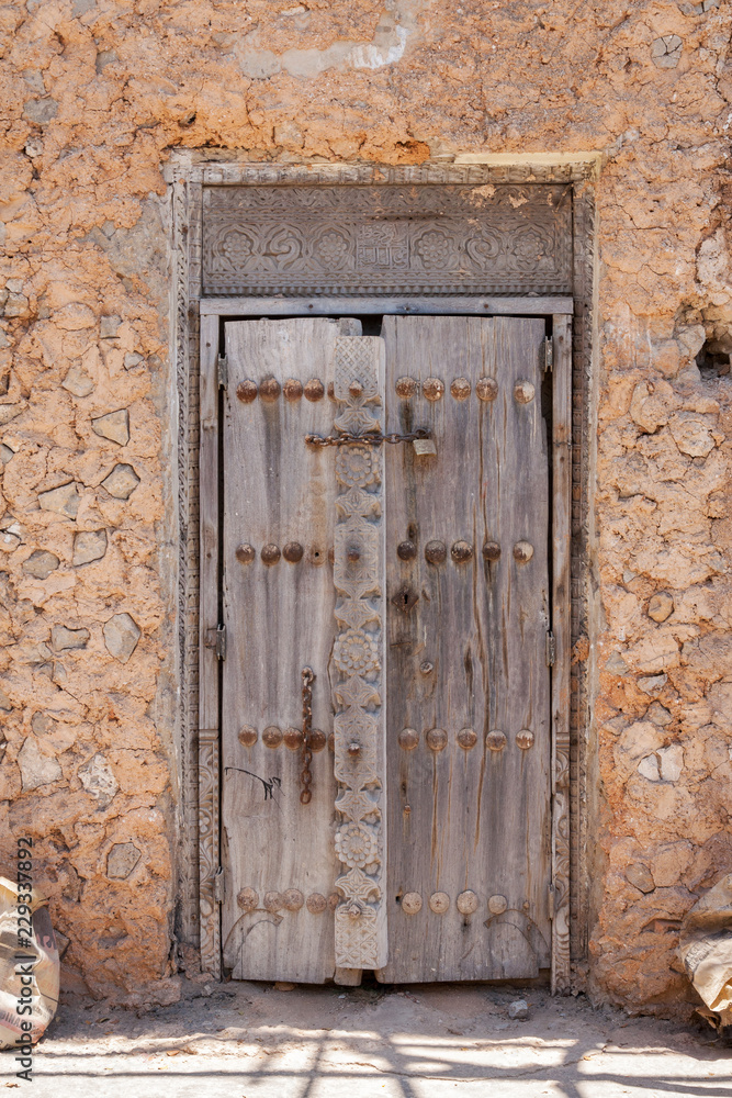 Decayed wooden door with Arabic culture element in Stone town, Zansibar island, Tansania - a UNESCO heritage