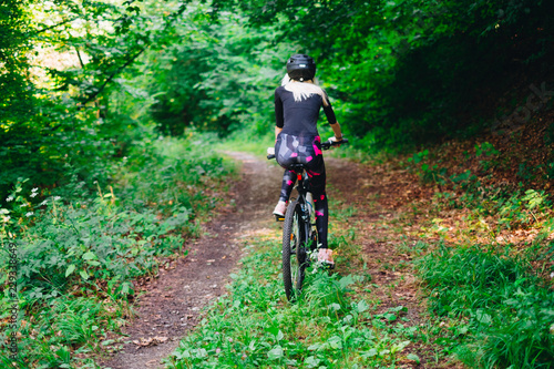 young woman on bicycle in forest