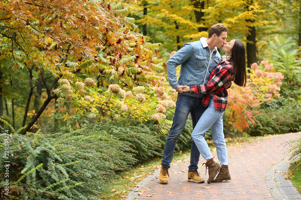 Fototapeta premium Loving young couple kissing on romantic date in autumn park