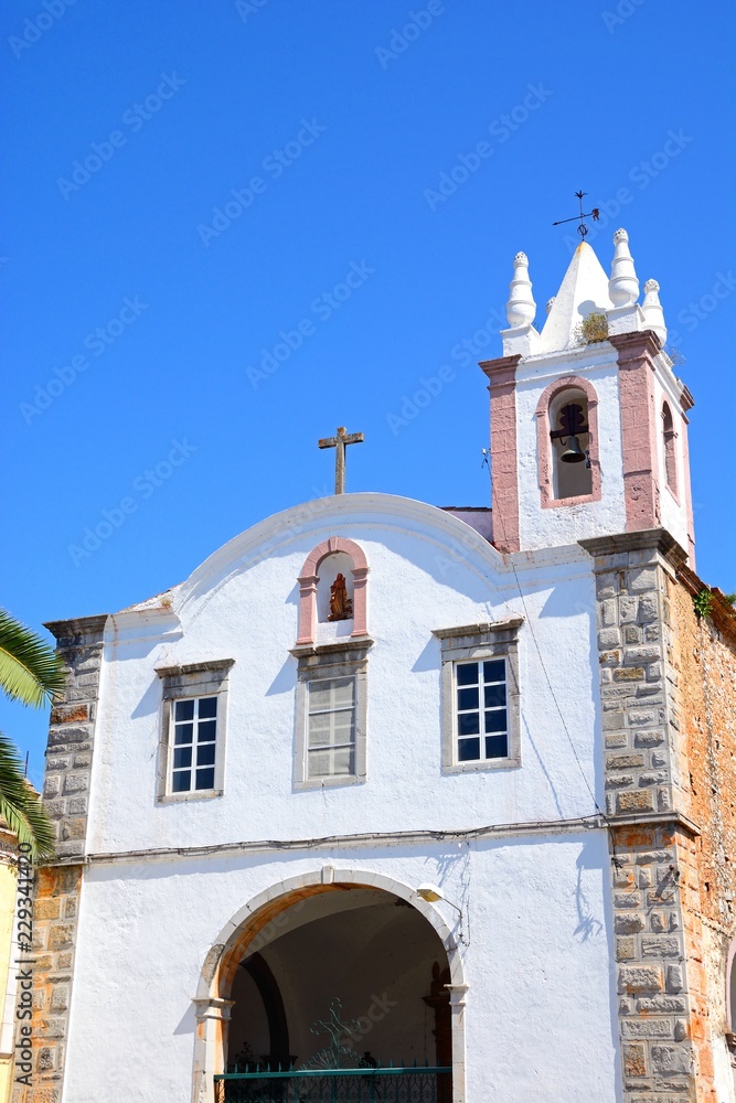 Fototapeta premium View of St Marys Church (Igreja de Santa Maria) along Praca Doctor Antonio Padinha, Tavira, Algarve, Portugal.