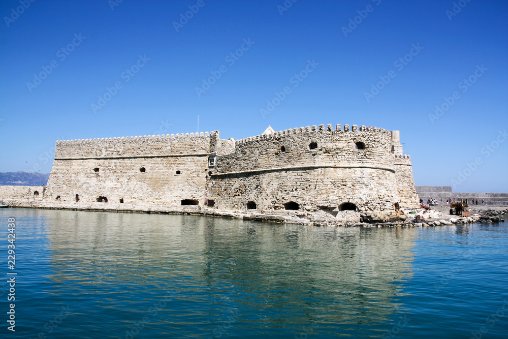 Venetian fort at Heraklion harbor under blue sunny sky in summer time, Crete Island, Greece
