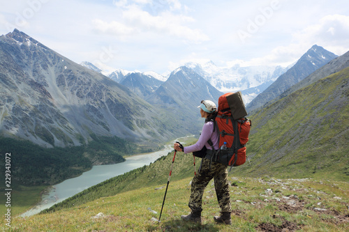 Tourist woman standing on Pass Kara-Turek against the Belukha Mountain and Akkem Lake, Altai, Russia