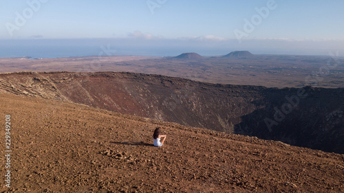 girl sitting on the top of a volcano