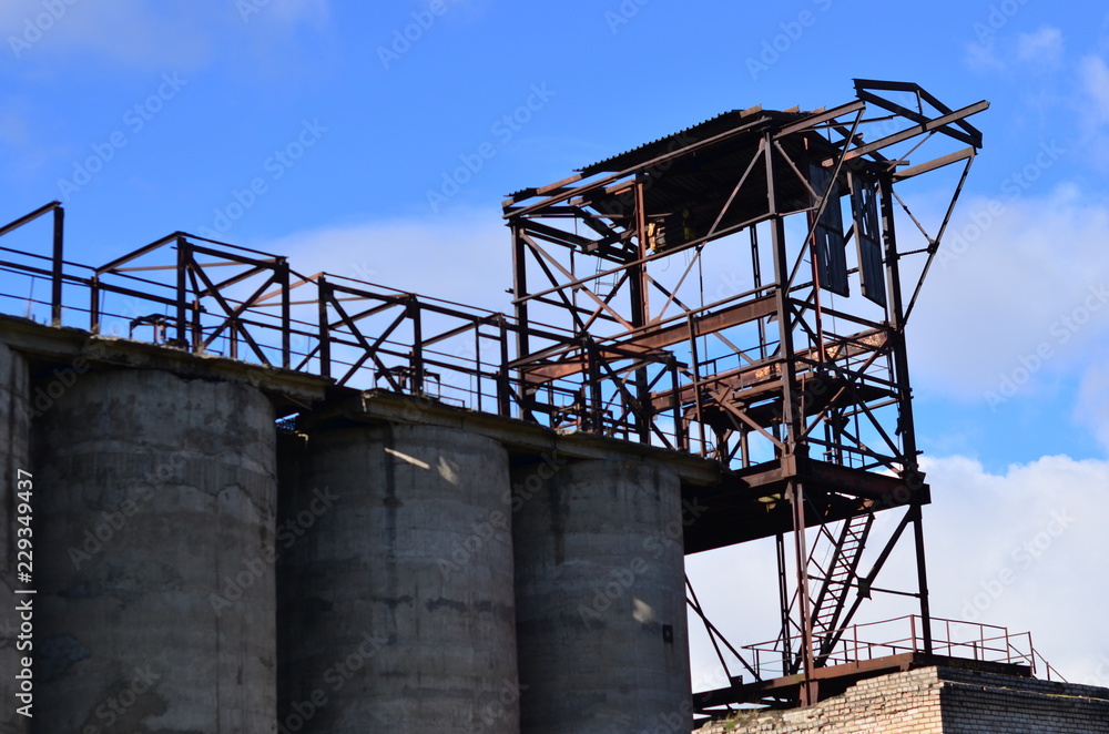 Large reinforced concrete pipe construction with a metal ladder against a bright blue sky. Abandoned Cement Plant Large reinforced concrete pipe construction with a metal ladder against a bright blue sky. Abandoned Cement Plant