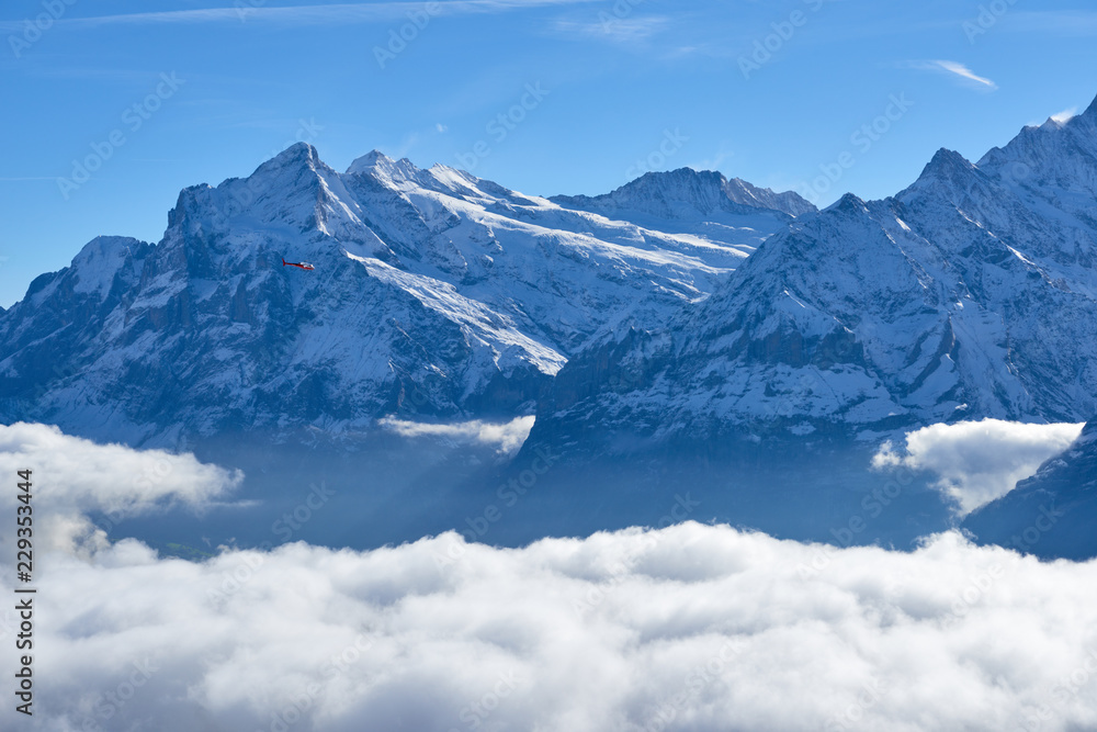 Mountain peak over clouds in the valley. Jungfrau region in Switzerland.