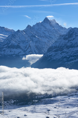 First snow and winter mountain landscape in mid october with clouds in the valley. Jungfrau region in Switzerland.