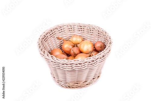 shallots in a wicker basket on a white background