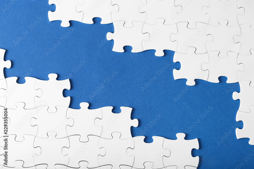 White puzzles on blue background top view with copy space White puzzles on blue background top view with copy space
