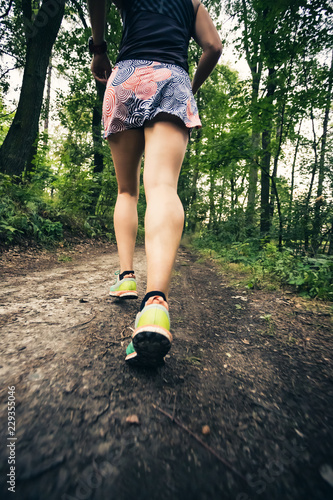 Trail running athletic woman in green forest, sports inspiration and motivation.