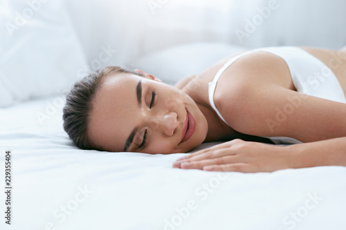 Beautiful Woman Sleeping On White Bed In Light Interior