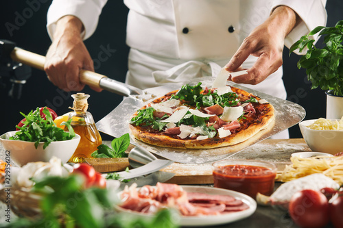 Fototapeta Naklejka Na Ścianę i Meble -  Chef preparing an Italian pizza on a paddle