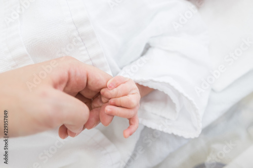 親の指を握る赤ちゃん