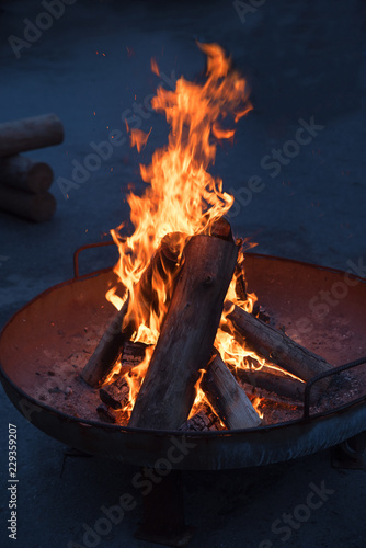 Feuerpfanne mit brennenden Holzscheiten Hochformat