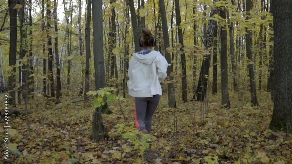 The girl runs slowly along the forest path.
The girl runs slowly along the forest path.