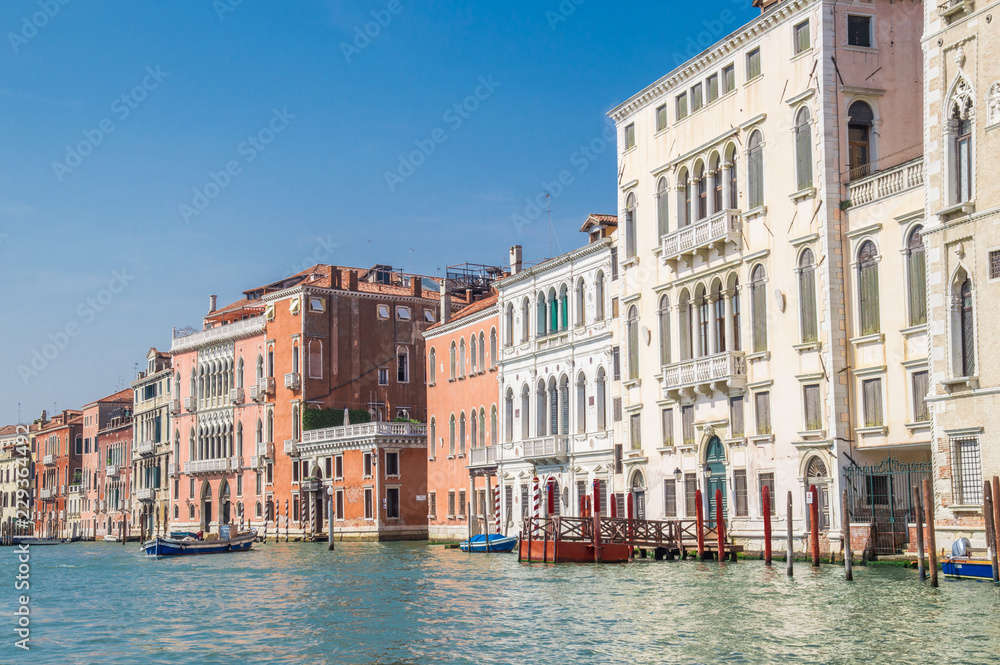 Residential buildings along the embankment of the Grand Canal. In the background, blue cloudless sky.