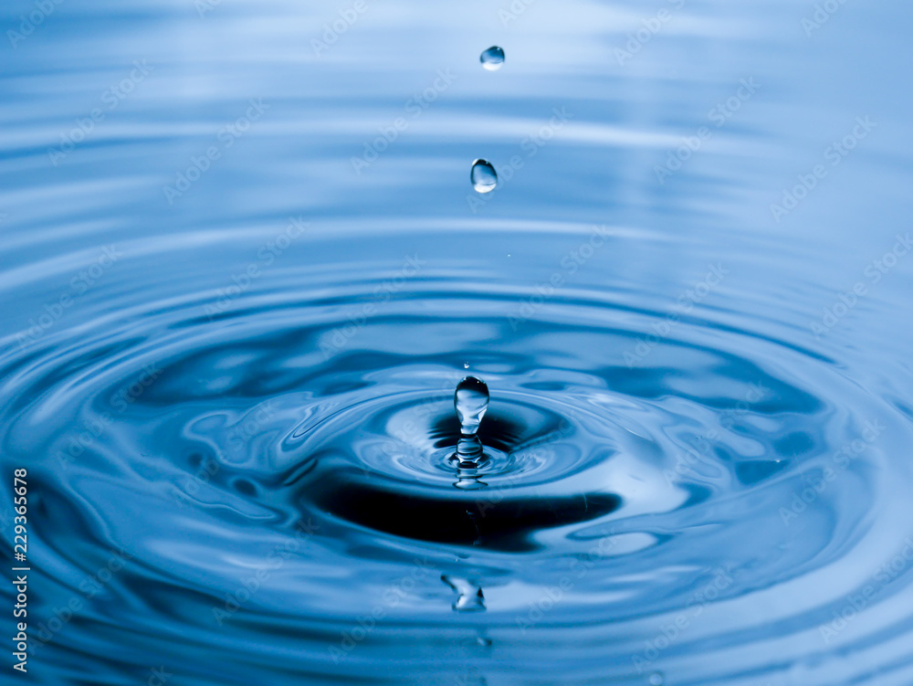 close up drop of water on blue background close up drop of water on blue background