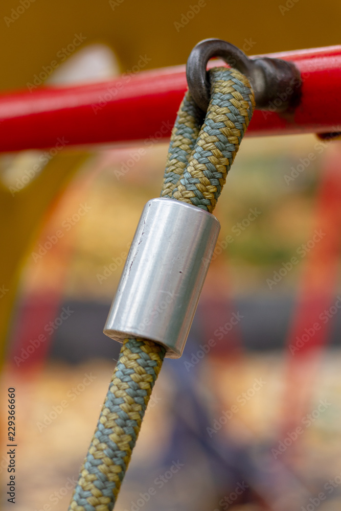 Fastening textile rope with a crimp to the metal loop. Tross with aluminum crimp clutch attached to a steel loop. Tensioned sling attached to a metal loop.