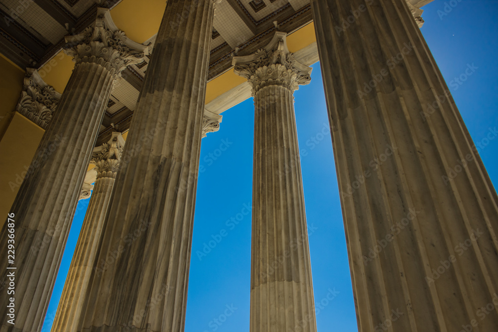 architecture building concept of ancient Greek temple with yellow marble columns on blue sky background
