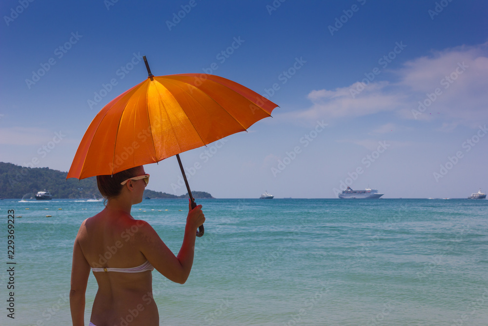 girl with orange umbrella on the beach in Thailand girl with orange umbrella on the beach in Thailand