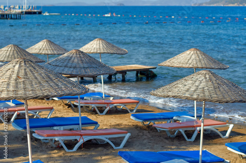 Beach wicker umbrellas on the coast of the Aegean Sea of Turkey.