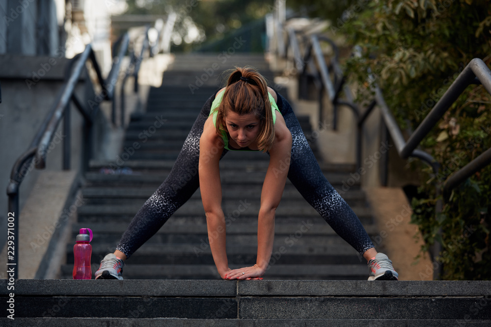 Portrait of sporty young woman doing stretching in city. Portrait of sporty young woman doing stretching in city.