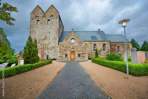 Aa church against cloudy sky in Aakirkeby, Denmark. It is the biggest and oldest church on the Bornholm island, constructed from greensand stone, dominates with its twin towers