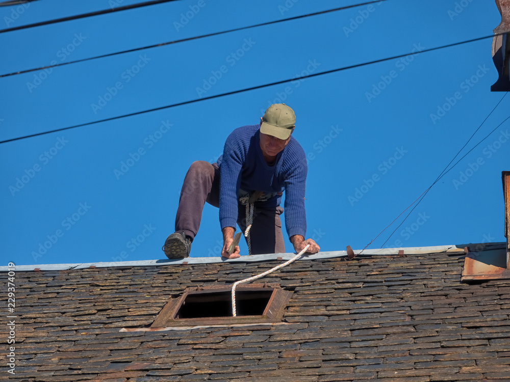 Maintenance of the roof of an old village house with slate tiles. Maintenance of the roof of an old village house with slate tiles.