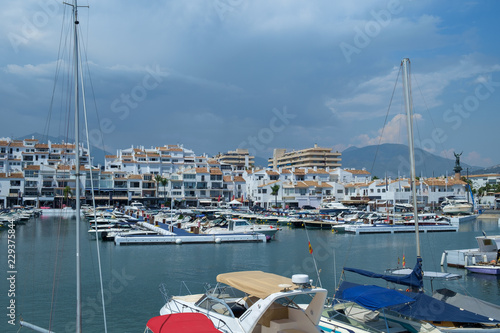 Puerto Banus, Marbella, Costa del Sol, Spain. Whitewashed buildings and shops serve as a backdrop to nthis harbour of marine vessels of all sizes from small dinghies to luxury yachts. photo