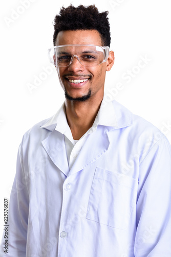 Studio shot of young happy African man doctor smiling while wear