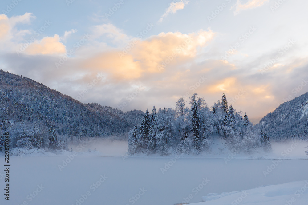 sunset at lake Weitsee in winter with smoke on water sunset at lake Weitsee in winter with smoke on water