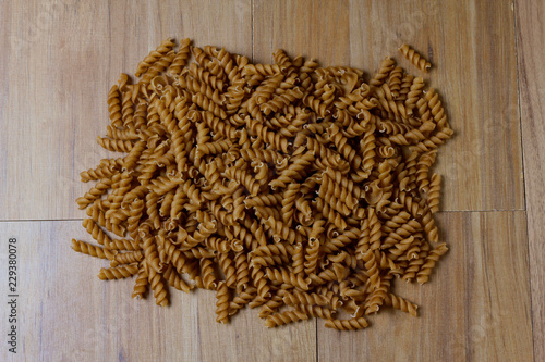portion of raw whole noodles, twisted, wooden table top view © AGPhotography