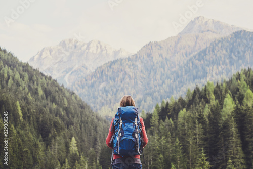 Young woman traveler in Alps mountains. Travel and active lifestyle concept