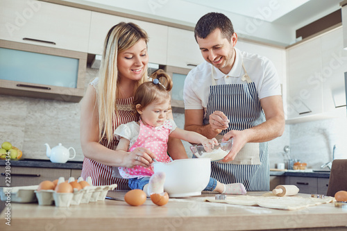 A happy family prepares baking in the kitchen.