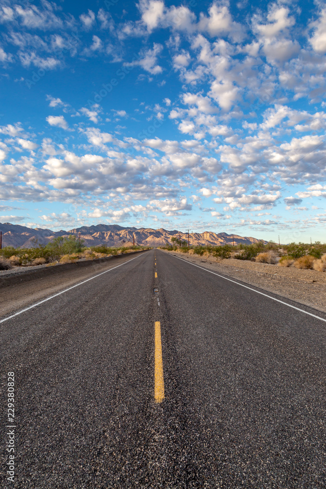 A long, straight road through the Californian desert, near Joshua Tree National Park A long, straight road through the Californian desert, near Joshua Tree National Park