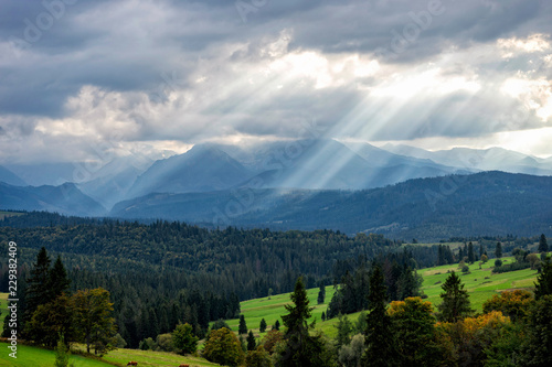 Scenic view of sun rays over mountain landscape. Beautiful summer landscape in High Tatras mountains. Sun rays over hills and valley.
