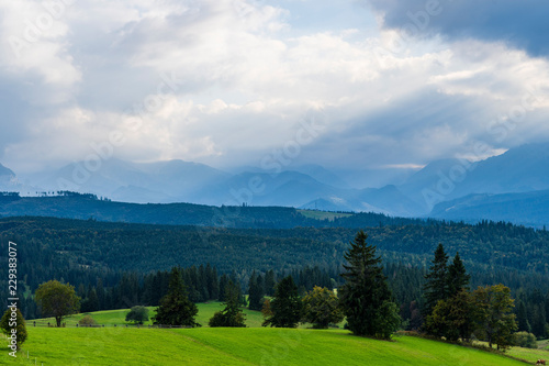 Scenic view of sun rays over mountain landscape. Beautiful summer landscape in High Tatras mountains. Sun rays over hills and valley. © 1tomm