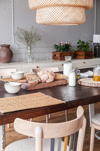 Close-up of bread, milk and food mat on a table in a kitchen interior on a countryside