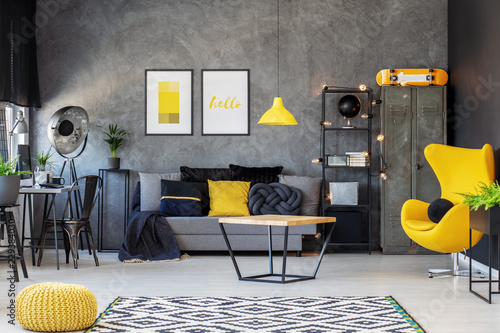Grey and yellow scandinavian living room with stylish egg chair, modern coffee table and comfortable couch with pillows