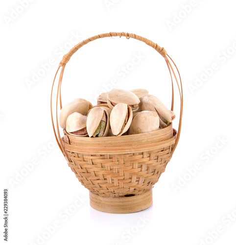 Pistachio nuts in basket on a white background.