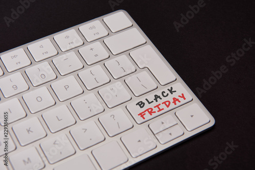 close-up shot of computer keyboard with black friday button isolated on black